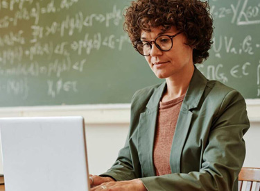 5-Useful-AI-Tools-for-Teachers-in-2024 Male teacher with elementary-age students surrounding him as he shows them how to use AI effectively on a tablet