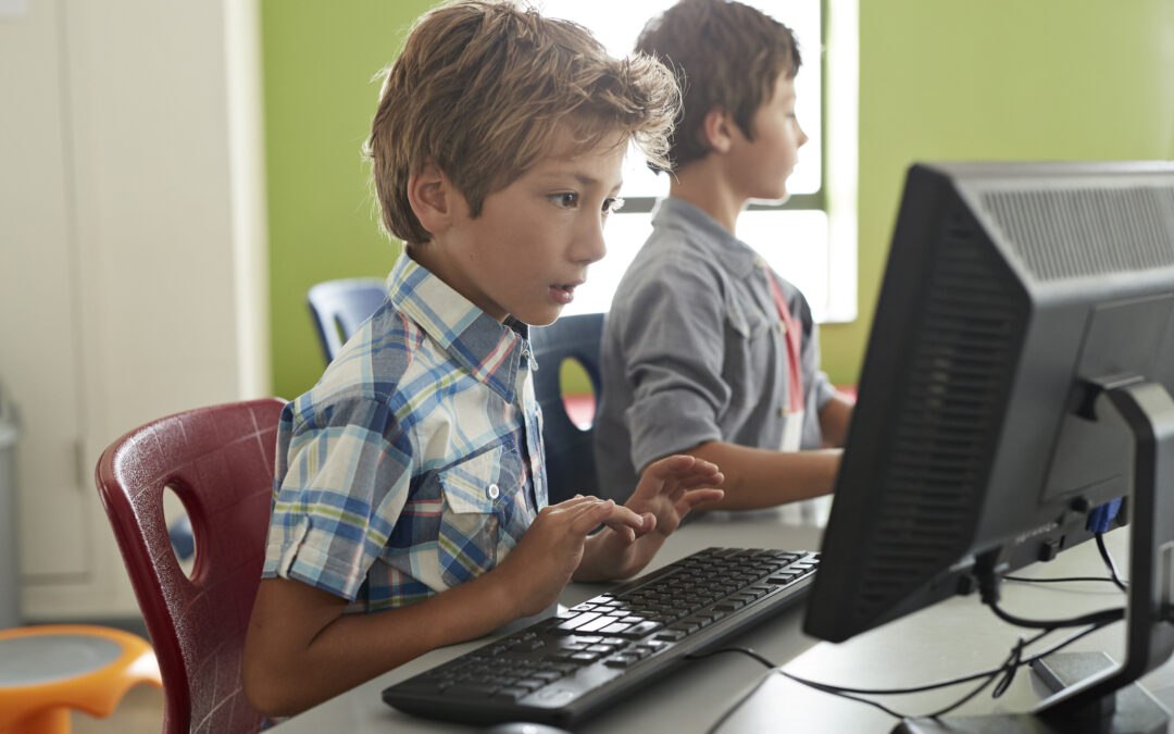 Children at computer class in elementary school learning digital literacy