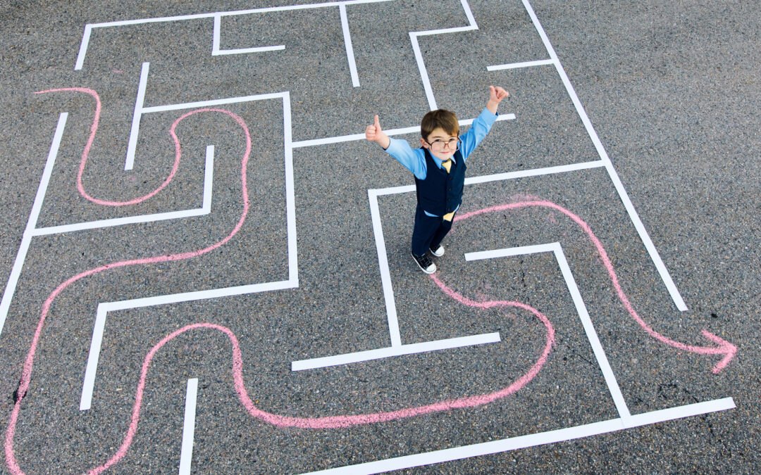 Young students standing in chalk maze giving thumbs up while practicing unplugged computer programming skills