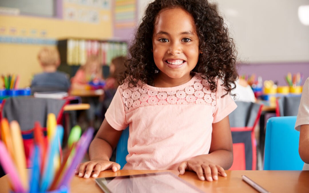 Young elementary student using digital tablet in art classroom