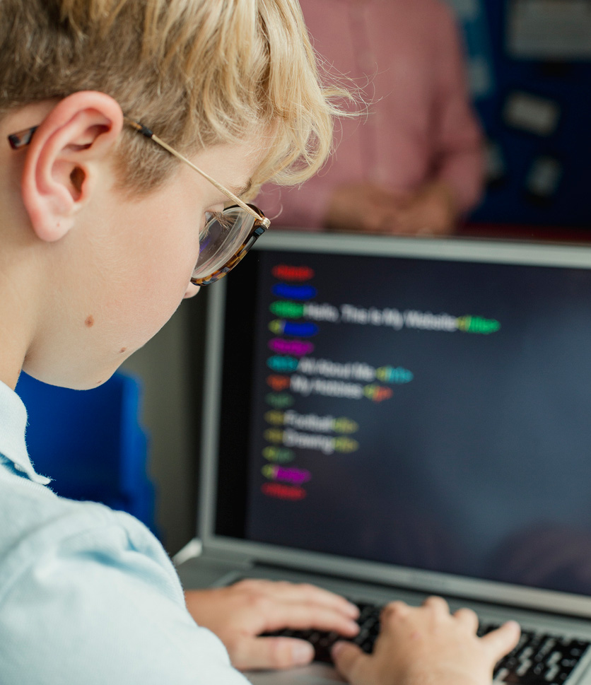 Boy on computer learning computer programming at school