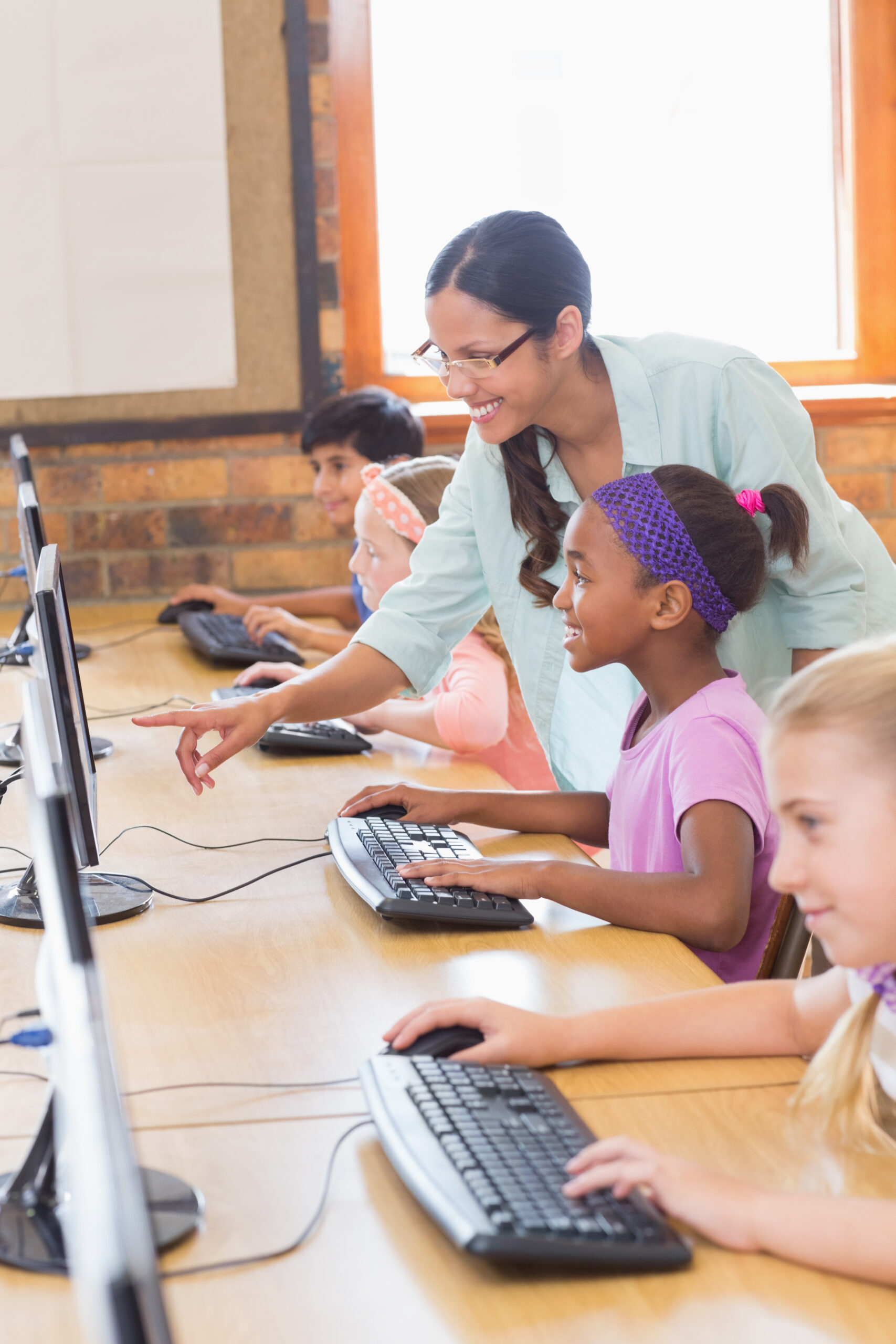 Early middle school male student standing, holding laptop in hand, and using AI to learn