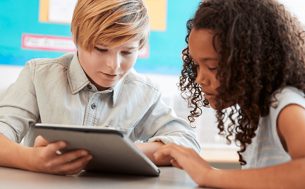 Young boy and girl student looking at edtech program on tablet